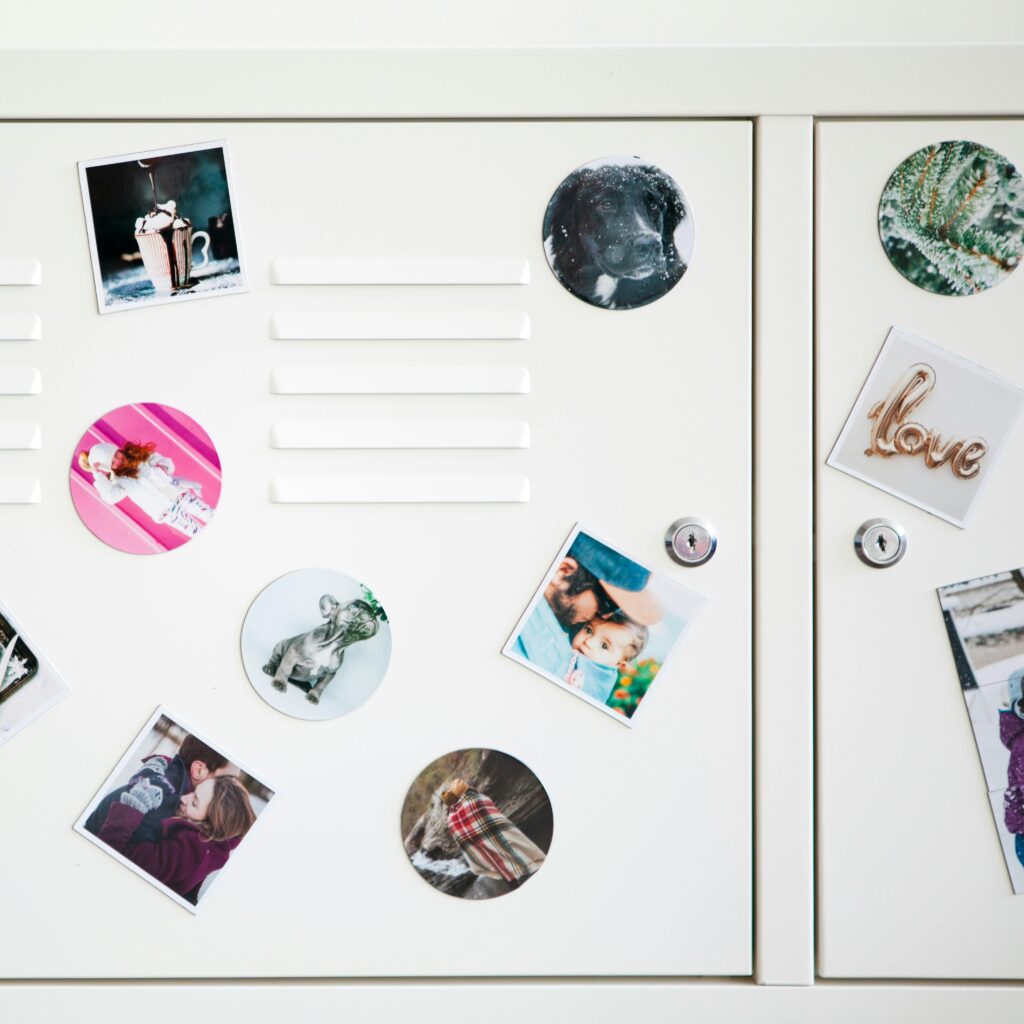 White locker adorned with various photo stickers, showcasing personal memories and artistic decoration.